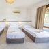 Akay Garden Family Club in Ildir: triple guest room with three single beds and window curtain