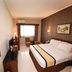 Hotel Nyland Pasteur Bandung guest room with king bed, chair, TV, window, and wall mirror in Bandung