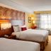 Courtyard by Marriott London guest room with two beds, desk, chair, and large window