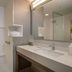 Courtyard by Marriott London bathroom with walk-in shower, double vanity and large mirror