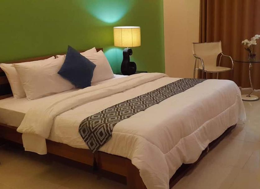 Ybc Grand Hotel in Olongapo guest room with a neatly made bed, bedside lamp, and seating area