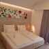 Forest Village Resort in Medjugorje: bright twin bed room with floral wall art and balcony curtains