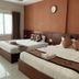 Volga Apartment Hotel in Mũi Né guest room with two double beds, window light, and wall clock