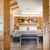 Family Hotel Serena in Andalo: cozy guest room with king bed, bench, wood accents, and floral wall art