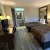 Super 8 by Wyndham Fayetteville guest room with two double beds, TV and vanity area