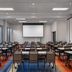 Hyatt House Emeryville/San Francisco Bay Area meeting room with rows of tables and chairs and a projection screen
