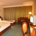 Majestic Oriental Hotel in Siem Reap guest room with two beds, TV, seating area and curtained window