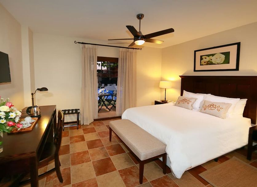 Hotel Cubitá Boutique Resort & Spa in Chitré: guest room with king bed, bench, desk and balcony access