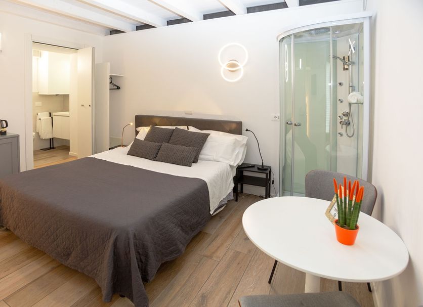 Giardino Giusti House & Court Verona guest room with bed, en suite glass shower and small table