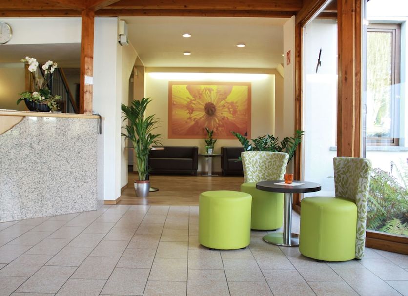 Landhotel Karrenberg in Kirchberg lobby with lime green stools, lounge seating and a reception desk