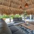 Grand Windsock Bonaire in Kralendijk: thatched-roof outdoor lounge with sofa, coffee table and poolside view