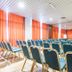 Europa Palace Hotel Messina conference room with rows of blue chairs and orange curtains