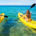 Koyao Island Resort in Ko Yao Noi with guests kayaking on clear turquoise water by the beach