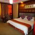 Jinluowan Hotel in Ji'an guest room with king bed, chairs and warm lighting