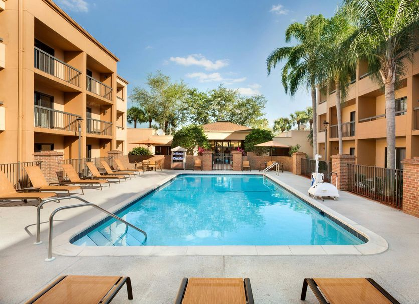 Courtyard by Marriott Fort Myers Cape Coral pool with palm trees and lounge chairs in Fort Myers
