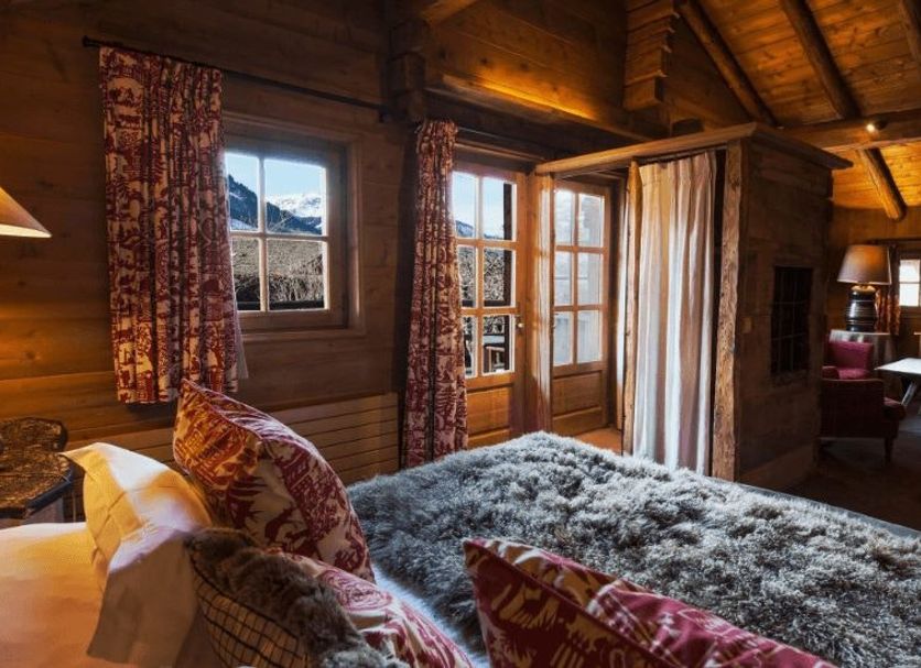 Les Fermes De Marie in Megève: cozy alpine suite with wood interior, king bed, and mountain-view windows
