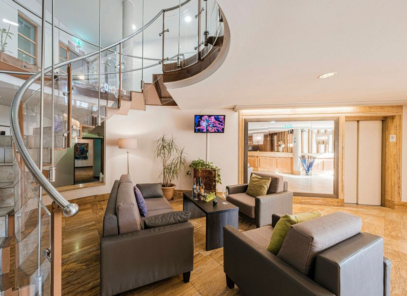 Hotel Pelikan in Schwäbisch Gmünd lobby with spiral staircase, seating area, and wood accents