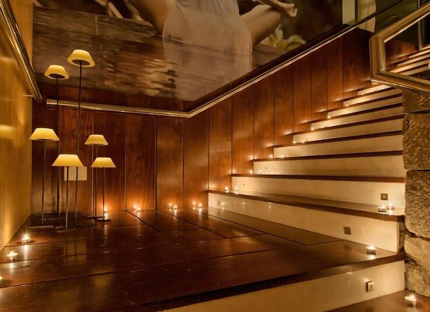 Hotel Balneario La Hermida in Tresviso: warm-lit indoor staircase with wood paneling and reflective ceiling