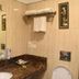 Hotel Clark Inn Kaushambi bathroom vanity with sink, mirror, towel rack and beige tiled walls in Ghāziābād