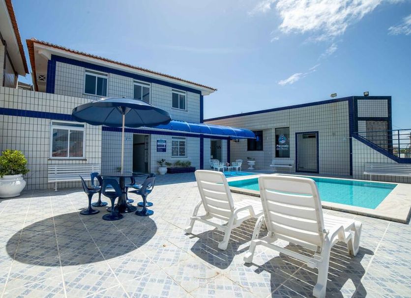 Hotel Pousada do Farol in Aracaju features a sunny courtyard pool with lounge chairs and umbrellas