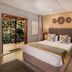 88 Baron van Reede Guesthouse in Oudtshoorn room with king bed, patio doors to garden, and seating area