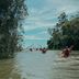 Kayakers on a river amid lush greenery at Puerto Valle Hotel De Esteros, Puerto Valle