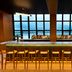 Wythe Hotel in Brooklyn bar with stools and a large windowed waterfront view