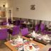 Hotel Le Canada in Hermanville-sur-Mer dining room with purple chairs and set tables