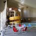 Medicine Hat Suites indoor pool area with water slide and red chairs in Medicine Hat