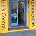 Entrance to Abel's Central Backpackers in Nelson with bright yellow doorway and glass door