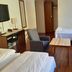 Hotel Noreg Ålesund guest room with twin beds, sofa, chair, and TV