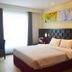 Grand Orchid Hotel Yogyakarta in Depok bedroom with king bed, large window and colorful wall art
