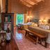 Hotel El Silencio del Campo in La Fortuna: rustic room with twin beds, tiled floors and jungle-view doorway