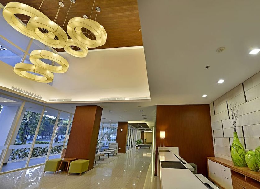 Whiz Prime Hotel Pajajaran Bogor lobby with modern circular ceiling lights and seating area