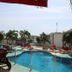 Hotel Kaamú Taganga pool with palm trees, red loungers and ocean-view deck in Taganga