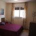 Águilas de los Collados hotel room in Águilas with double bed, window, and patterned curtains