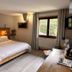Hotel La Fontaine in Les Houches guest room with bed, window view, and seating area