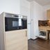 Apparthotel Privilodges Carré de Jaude kitchenette with oven, sink, and wood cabinets in Clermont-Ferrand
