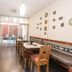 B&B Wasi Airport Lima dining area with wooden tables, bench seating, and sliding glass doors in Lima