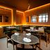 Wythe Hotel in Brooklyn restaurant interior with warm wood paneling, mirrors, and set dining tables
