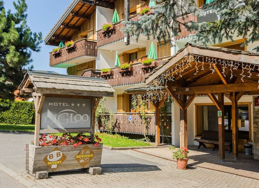 Hotel Igloo in Morzine with alpine lodge entrance, balcony flower boxes, and wooden canopy