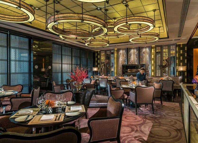 Four Seasons Hotel Shenzhen dining room with circular ceiling lights and set tables in Shenzhen