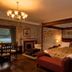 The Whispering Pine Lodge in Spean Bridge bedroom with four-poster bed, fireplace and lake view