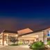 Baymont by Wyndham Topeka exterior at dusk with illuminated entrance and sign