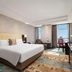 Huihao Hotel Wuhan guest room with king bed, city view window, desk and seating area