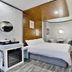 Hotel Atti Incheon guest room with bed, wall-mounted TV, seating area, and wood ceiling detail