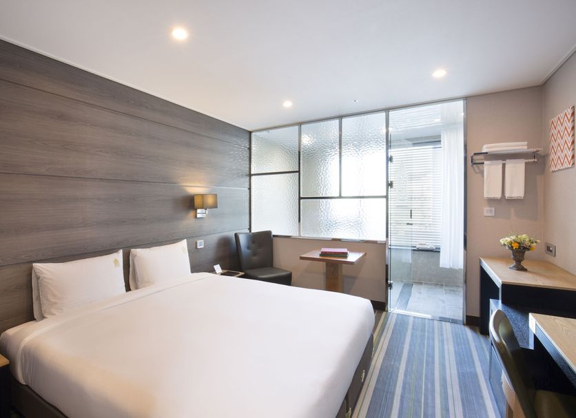 Benikea Hotel Haeundae in Busan guest room with queen bed, desk, chair, and large window
