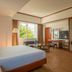 Centara Life Hotel Mae Sot guest room with king bed, seating area, TV and large window view of greenery