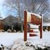 Tussock Grove Boutique in Ohakune covered in snow with trees and a wooden entrance sign