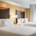 Fairfield Inn and Suites by Marriott Weirton guest room with two white beds and bedside lamp